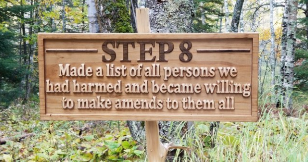 a carved wooden sign that says "Step 8: Made a list of all persons we had harmed and became willing to make amends to them all."